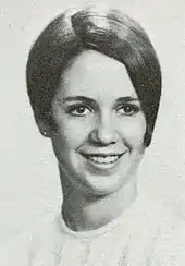 A smiling young woman with short hair parted on the side