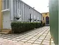 Exterior view of a gallery with fixed wood louvers in a "martillo" (ell) extension to the house at Calle Mayor #14 (Casa Paoli)