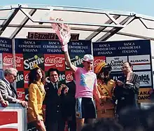 A man holding flowers while wearing a pink jersey.