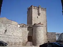 Coria castle.  Basically a large square keep, but with several smaller round towers jutting out on all side.