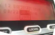 A red-backlit LCD screen above three labelled rubber buttons shows a dropdown selector for dates.