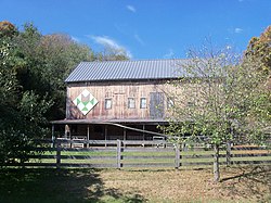 A barn has a stylized chalice painted on side facing Route 643