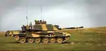 photo of a Challenger 2 tank at speed on grassy plain