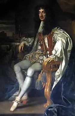 Painting of seated male figure, with long black hair wearing a white cape and breeches.