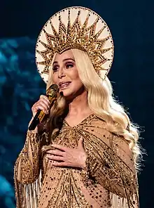 A photograph of Cher performing in London during her Here We Go Again Tour in October 2019