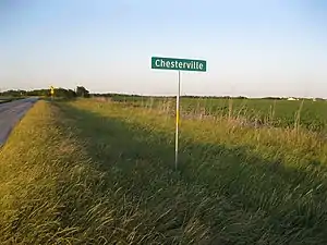 Sign on FM 2764 looking northeast across fields