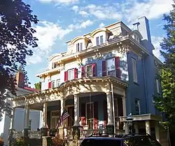 Front view of Chichester House, mottled by sun and shadow from nearby tree