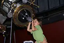 A young girl observing the solar eclipse at the Chamberlain observatory in Denver, Colorado