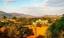 A set of trees and settlement with hills in the background