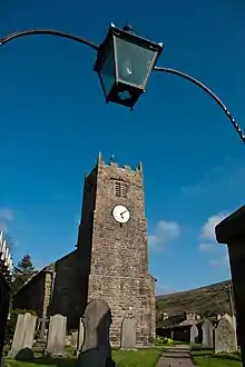 A church on a sunny day framed by a iron gateway