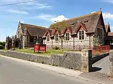 Picture of Churchill Methodist Church in Front Street, Churchill, taken from the opposite side (south) of the road. The cemetery is shown surrounded by red railings.