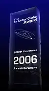 A glass 2006 Clarke Award, stating in white text "The Sir Arthur Clarke Award. BROHP Conference, 2006 Awards Ceremony".