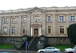 Photograph of a large two-story building with exposed basement