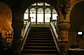 Victorian Gothic Revival vestibule with faux-marbled pillars, staircase and stained glass window.