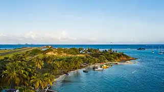 Areal view of a beach on Union Island near Clifton with the Union Island Airport in the background.