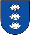 A coat of arms depicting three white flowers lined up vertically with four yellow seeds surrounding each all on a blue background