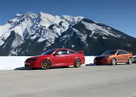 A pair of two-door passenger cars with rear wings.