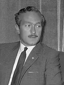 Black and white photograph of Colin Chapman in formal uniform and speaking to a man on his left