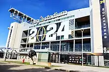 The exterior of a domed football stadium with a sign on its exterior reading "2024"