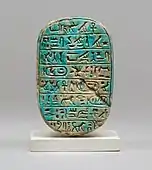 The back of a commemorative scarab of Amenhotep III, recording a lion hunt; 1390–1352 BC; blue glazed steatite; length: 8 cm; Metropolitan Museum of Art