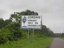 Translation of the sign:Coronie: peaceful, free and friendly