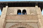 The decoration above the archway of the entrance, including the Kufic inscription