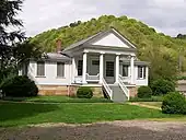 old white one-story house with four columns in front