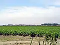 Creil as seen from a distance over crop fields.