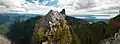 bare rock subpeak with one hiker on top with Vancouver in the background