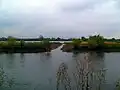 The larger lake viewed across the lower Tame from the National Memorial Arboretum, showing a connecting channel, allowing flood water to flow between river and lake.