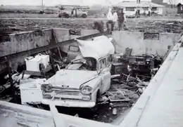 A mangled truck in the basement of a home that has been swept from its foundation