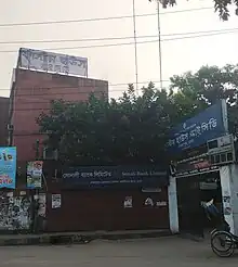 An unremarkable building with a small gate offset on the road