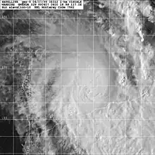 Satellite image of a weakening tropical cyclone. The cloud cover of the storm is becoming elongated to the north and east and constrained elsewhere. No eye is present within the storm. Part of Northwestern Australia can be seen at the bottom-right of the image.