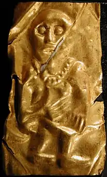 A goldleaf depicting a man with large eyes who holds his hands on his chest