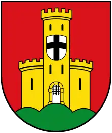 A shield with a red background, an orange castle in ruins, has a second shield of silver with a black cross.