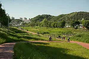 Cyclists and pedestrians move along a riverway in Daejeon, Korea