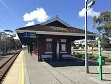 Small brick building on bitumen station platform