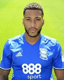 Dark-skinned man wearing blue sports kit