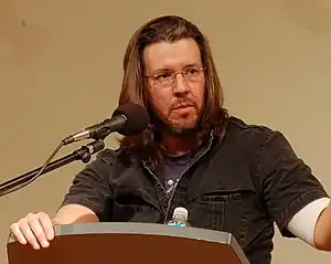 David Foster Wallace speaking at a podium