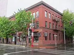 Photography of a three-story red brick building from across the street