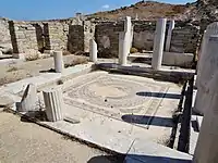 Peristyle courtyard flanked by columns that surround a mosaic floor