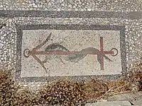 A mosaic with a dolphin and anchor design