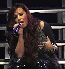 A woman wearing a black outfit while singing.