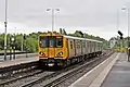 A Merseyrail Class 507 departs from Hooton, heading for Chester.