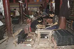 People printing books inside the monastic print house in 2009 (photograph Mario Biondi). More than a hundred workers manually print secular and religious books from hand-cut woodblocks.