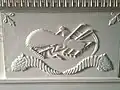 Detail of the Clover Forest mantel showing the agricultural implements symbolizing Captain Thomas Pemberton's return to agrarian life.