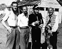 1948 B&W photograph of Donn Reynolds (far left) on the film set of Eureka Stockade standing with Peter Finch, Grant Taylor, and Sydney Loder (New South Wales, Australia).