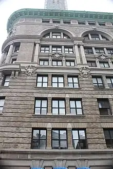 View of the westernmost bay on Willoughby Street. The lower four stories are clad in limestone and have rectangular windows. The upper four stories are clad in brick and terracotta; the fifth and sixth stories contain a double-height window, while the seventh story has an arched window. There is a cornice above the eighth story.