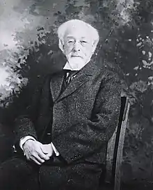 Three-quarter length, seated in chair, front pose, tweed suit, very old man