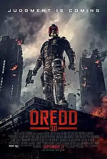 A futuristic police officer in armour and a helmet that covers all but his mouth stands on the corner of a building roof with a gun in his hand as large tower blocks burn behind him. Above the man reads a tagline "Judgment Is Coming".